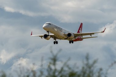 Zurich, Switzerland, June 16, 2024 HB-JVO Helvetic Airways Embraer E190LR aircraft is landing on runway 14 clipart