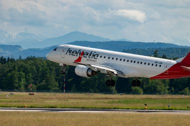 Zürih, İsviçre, 16 Haziran 2024 HB-JVN Helvetic Airways Embraer E190LR uçağı 14 numaralı piste iniyor.