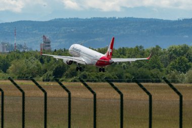 Zürih, İsviçre, 16 Haziran 2024 HB-JVP Helvetic Airways Embraer E190LR uçağı 14 numaralı piste iniyor.