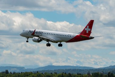 Zürih, İsviçre, 16 Haziran 2024 HB-JVY Helvetic hava yolları Embraer E190LR uçağı 14 numaralı piste iniyor.