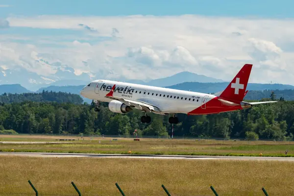 stock image Zurich, Switzerland, June 16, 2024 HB-JVM Helvetic Airways Embraer E190LR aircraft is landing on runway 14