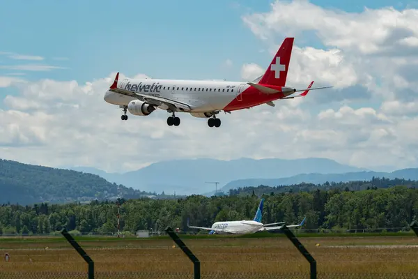 stock image Zurich, Switzerland, June 16, 2024 HB-JVP Helvetic Airways Embraer E190LR aircraft is landing on runway 14