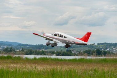 Wangen-Lachen, İsviçre, 26 Mayıs 2024 HB-PPW Piper PA-28 Archer II pervane uçağı küçük bir havaalanından kalkıyor.