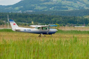 Wangen-Lachen, Switzerland, May 26, 2024 HB-CNS Reims Cessna F152 propeller plane is departing from a small airfield clipart