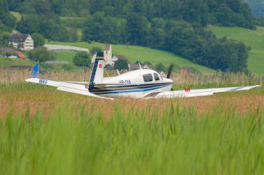 Wangen-Lachen, İsviçre, 26 Mayıs 2024 HB-DIA Mooney Mooney M20J pervane uçağı küçük bir havaalanına iniyor.