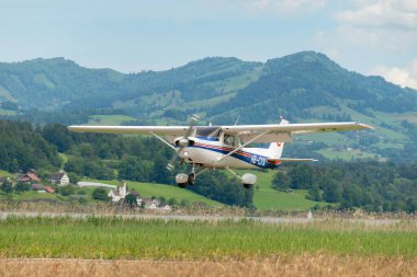 Wangen-Lachen, Switzerland, May 26, 2024 HB-CYX Cessna 152 propeller plane is landing on a small airfield clipart