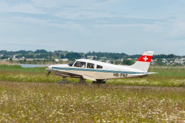 Wangen-Lachen, Switzerland, May 26, 2024 HB-PKF Piper PA-28-236 propeller plane is arriving on a small airfield clipart