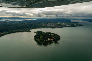 Mainau, Almanya, 19 Ağustos 2024. Küçük bir uçakla Constance Gölü 'ndeki adanın üzerini görün.