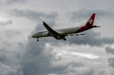Zürih, İsviçre, 14 Eylül 2024 HB-EZJ Helvetic Hava Yolları Embraer E195-E2 uçağı bulutlu bir günde 14. piste iniyor.