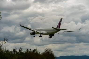 Zurich, Switzerland, September 14, 2024 A7-ALG Qatar airways Airbus A350-941 aircraft is landing on runway 14 on a cloudy day clipart