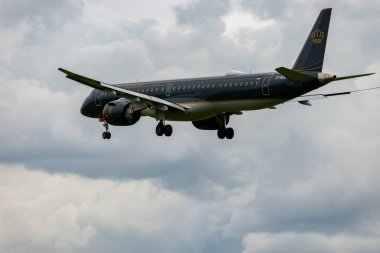 Zürih, İsviçre, 14 Eylül 2024 Ürdün Kraliyet Embraer E195-E2 uçağı bulutlu bir günde pist 14 'e iniyor.