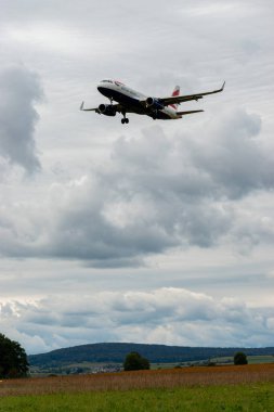 Zürih, İsviçre, 14 Eylül 2024 G-EUYT British Airways Airbus A320-232, bulutlu bir günde pist 14 'e iniyor.