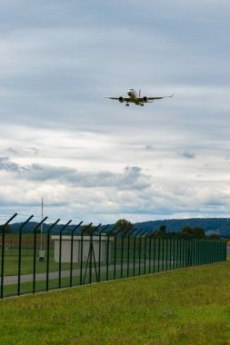 Zürih, İsviçre, 14 Eylül 2024 HB-JCU İsviçreli bombardıman uçağı CS-300 veya Airbus A220-300 uçağı bulutlu bir günde 14 nolu piste iniyor.
