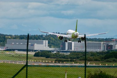 Zurich, Switzerland, September 14, 2024 YL-ABP Air Baltic Bombardier CS-300 or Airbus A220 aircraft is landing on runway 14 on a cloudy day clipart