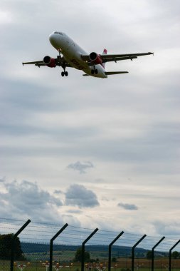 Zürih, İsviçre, 14 Eylül 2024 OE-LBQ Avusturya Havayolları Airbus A320-214, bulutlu bir günde pist 14 'e iniyor.
