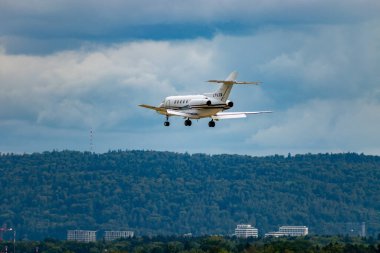 Zürih, İsviçre, 14 Eylül 2024 LY-LTA Hawker 800XP iş uçağı bulutlu bir günde 14. piste iniyor.