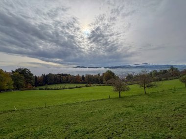 Saint Gallen, İsviçre, 19 Ekim 2024 Sonbaharda yeşil bir tepeden görülen bir vadi üzerindeki toz.