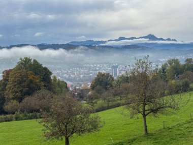 Saint Gallen, İsviçre, 19 Ekim 2024 Sonbaharda yeşil bir tepeden görülen bir vadi üzerindeki toz.