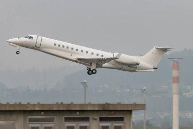 Zürih, İsviçre, 19 Ocak 2025 9H-WFC AirX Embraer AirX Miras 600 uçak, Davos 'taki dünya ekonomik forumunda sisli bir günde, 28 numaralı pistten kalkıyor.