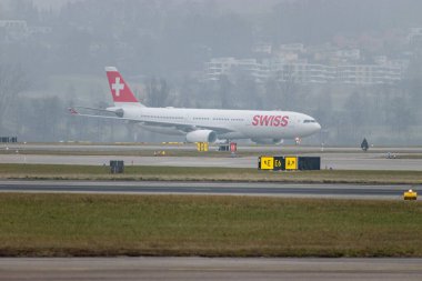 Zürih, İsviçre, 19 Ocak 2025 HB-IHJ İsviçre Airbus A330-343 çok sisli bir günde uçuyor.