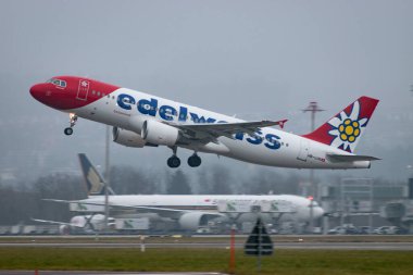 Zürih, İsviçre, 19 Ocak 2025 HB-IJW Edelweiss Airbus A320-214 çok sisli bir günde 28 numaralı pistten kalkıyor.