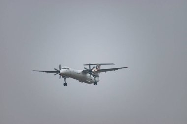 Zürih, İsviçre, 19 Ocak 2025 9A-CQA Hırvatistan Havayolları De Havilland Dash 8-400 turboprop uçağı çok sisli bir günde 14 nolu piste iniyor.