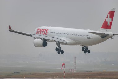 Zürih, İsviçre, 19 Ocak 2025 HB-JHF İsviçre Airbus A330-343 uçağı çok sisli bir günde 14. piste iniyor.