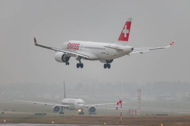 Zürih, İsviçre, 19 Ocak 2025 HB-JBH İsviçre Airbus A220-100 veya Bombacı CS-100 uçağı çok sisli bir günde 14. piste iniyor.