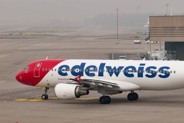 Zürih, İsviçre, 20 Ocak 2025 HB-JJL Edelweiss Airbus A320-214 çok sisli bir günde kalkıyor.