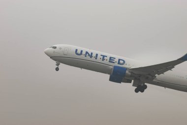 Zürih, İsviçre, 20 Ocak 2025 N-662UA Birleşik Havayolları Boeing 767-32ER uçağı çok sisli bir günde 16. pistten kalkıyor.
