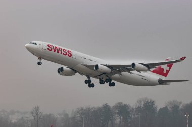 Zürih, İsviçre, 20 Ocak 2025 HB-JMB İsviçre Airbus A340-313 çok sisli bir günde 16. pistten kalkıyor.