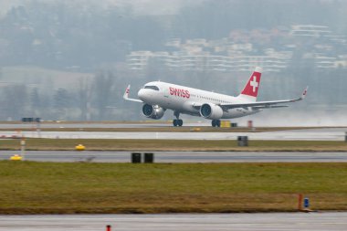 Zürih, İsviçre, 22 Ocak 2025 İsviçre HB-JDH İsviçre Airbus A320-271N uçağı yağmurlu bir günde 28 numaralı pistten kalkıyor.