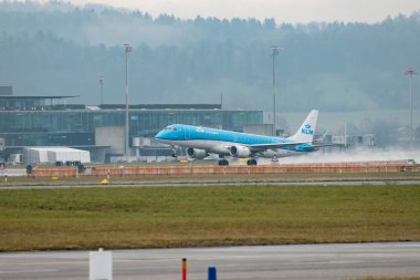 Zürih, İsviçre, 22 Ocak 2025 PH-EZV KLM Hollanda Kraliyet Havayolları Embraer E190STD uçağı yağmurlu bir günde 28. pistten kalkıyor.