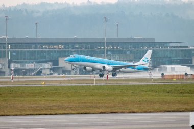Zürih, İsviçre, 22 Ocak 2025 PH-EZV KLM Hollanda Kraliyet Havayolları Embraer E190STD uçağı yağmurlu bir günde 28. pistten kalkıyor.
