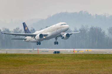 Zürih, İsviçre, 22 Ocak 2025 HZ-ASC Saudia Airbus A320-214 uçağı yağmurlu bir günde 16 numaralı pistten kalkıyor.