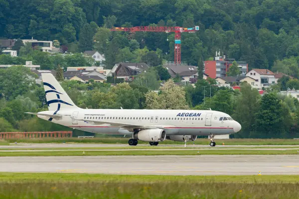 Zürih, İsviçre, 16 Mayıs 2025 SX-DVH Ege Havayolları Airbus A320-232 uçak giriş kapısına yanaşıyor.