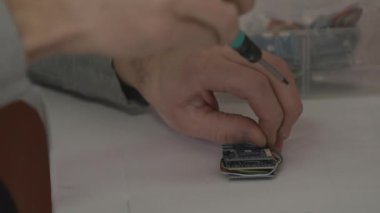 Tamir servisi konsepti. Bir elektronik tamircisi iki mikro devre çevirir.