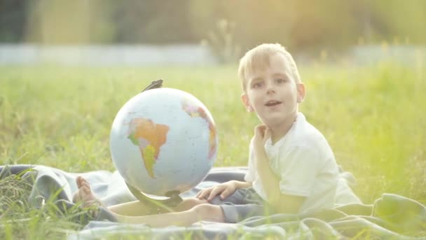小男孩在球场上玩地球仪 慢动作日落时分 — 图库视频影像