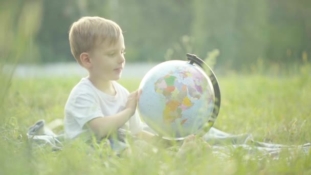 Malý Chlapec Obejme Glóbus Usměje Zpomal Západ Slunce — Stock video