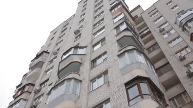 Balkonları tuğla şeklinde olan bir evin ön cephesi.