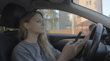 Araba kullanırken akıllı telefon kullanan kadın.