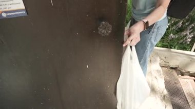 Koyu yüzey yakınlarında beyaz çanta taşıyan kişi.