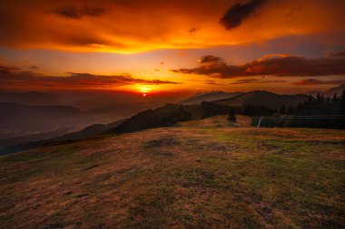 Slovenya, Avusturya ve İtalya sınırındaki dağlarda romantik renkli gündoğumu. Güneşin tüm gökyüzünü ve bulutları renklendirdiği nefes kesici bir an..