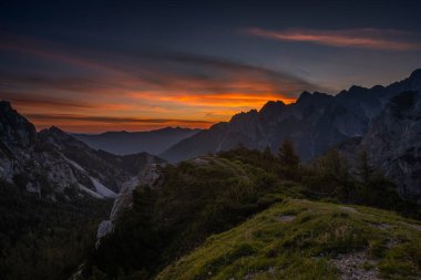 Slovenya 'nın Triglav Ulusal Parkı' ndaki Julian Alps 'in kalbindeki dağlarda romantik renkli bir gün doğumu. Güneşin tüm gökyüzünü ve bulutları renklendirdiği nefes kesici bir an..