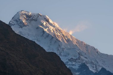 Güney Annapurna 'nın karlı zirvesinin nefes kesen manzarası bulutlar Nepal' deki büyük Himalayalar 'daki dağları usulca sardığında.