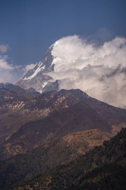 Güney Annapurna 'nın karlı zirvesinin nefes kesen manzarası bulutlar Nepal' deki büyük Himalayalar 'daki dağları usulca sardığında.