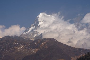 Güney Annapurna 'nın karlı zirvesinin nefes kesen manzarası bulutlar Nepal' deki büyük Himalayalar 'daki dağları usulca sardığında.