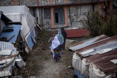 Nepal 'deki büyük Himalaya dağlarında küçük bir köy olan Ghorepani' nin sokaklarında soğuk bir gece geçirmek için sığınak arayan kadınlar..