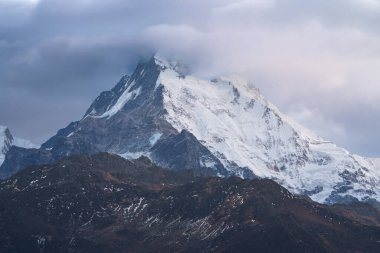 Güney Annapurna 'nın karlı zirvesinin nefes kesen manzarası bulutlar Nepal' deki büyük Himalayalar 'daki dağları usulca sardığında.