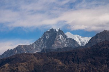 Machapuchare 'nin karla kaplı zirvesinin nefes kesen manzarası bulutlar Nepal' deki büyük Himalayalar 'daki dağları usulca sardığında.